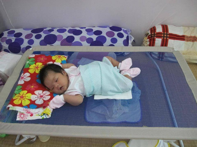 trẻ nằm giường lưới